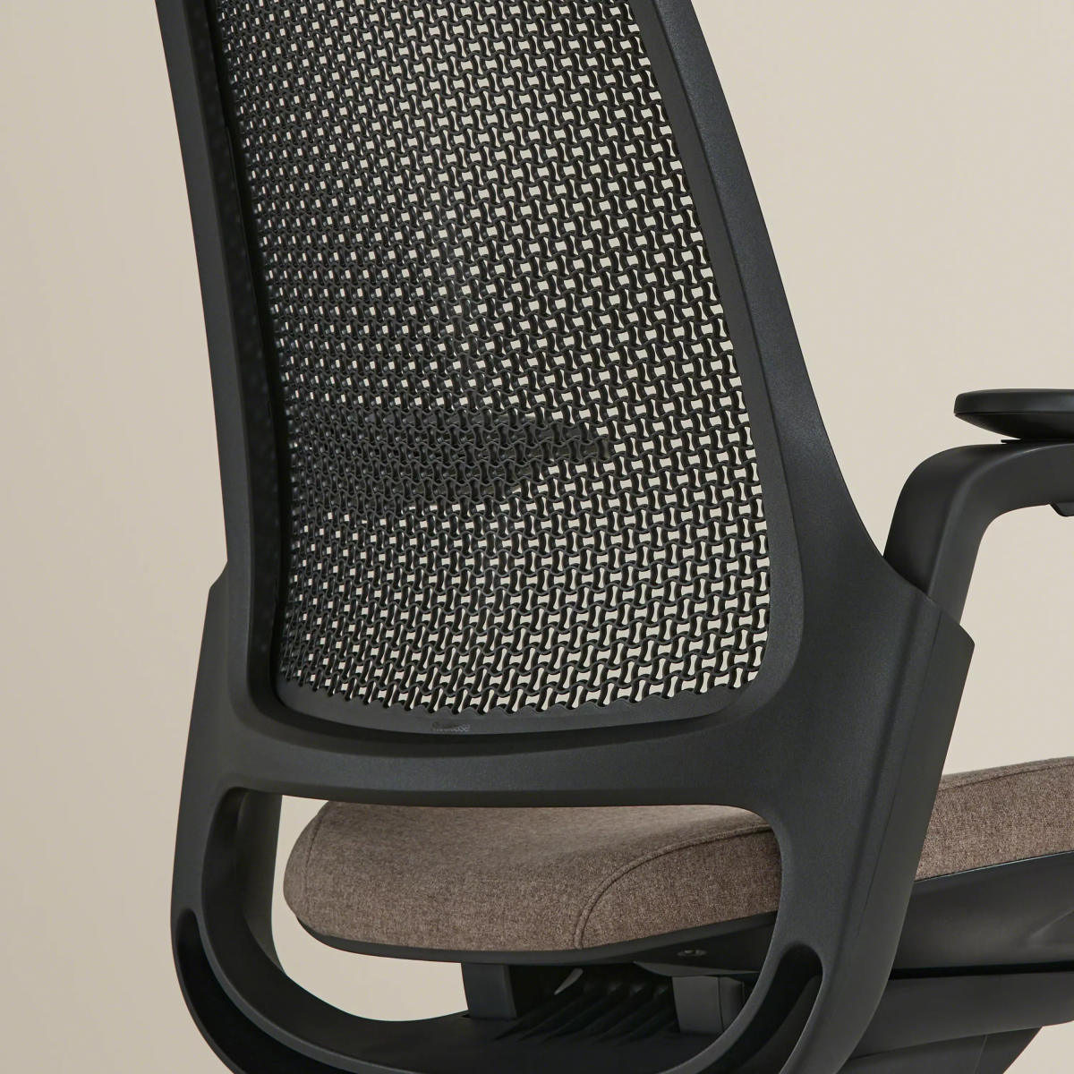 Close-up of the chair's black mesh back and armrest, showcasing structure and padding.