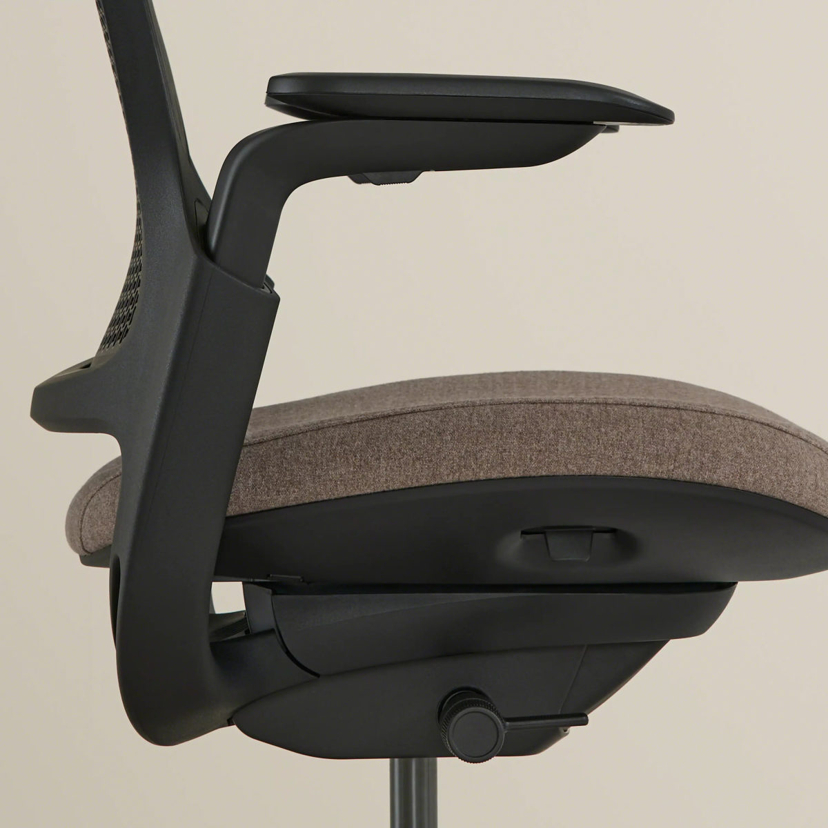 Side view of the chair highlighting seat cushion and underside controls.
